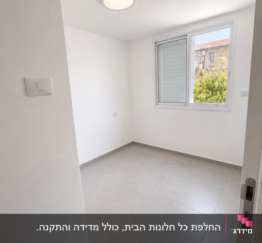 חלון אלומיניום לבן מותקן בחדר מגורים מוארת ונקייה